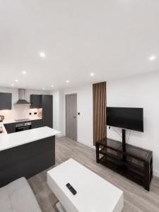 a kitchen and a living room with a tv at AS Residences in Preston