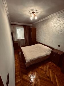 a bedroom with a bed and wooden floors at Goris Central House in Goris