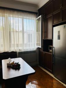 a kitchen with a table and a refrigerator at Goris Central House in Goris