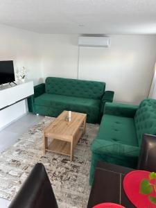 a living room with a green couch and a coffee table at Sarajevo Days in Binježevo
