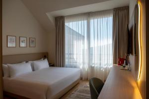ein Hotelzimmer mit einem Bett und einem großen Fenster in der Unterkunft Ridge Hotel Ehden in Ehden