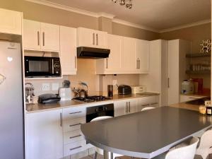 a kitchen with white cabinets and a counter top at Beautiful 3 bedroom flat in Grahamstown