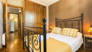 a bedroom with a black bed with orange and yellow pillows at Chez Bonheur in Osséja