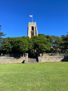 a clock tower with a flag on top of it at Beautiful 3 bedroom flat in Grahamstown +2 photos