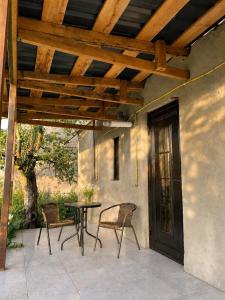 a patio with a table and chairs and a wooden pergola at Cherry Guesthouse in Tsalka