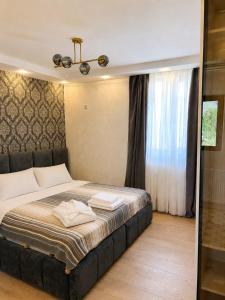 a bedroom with a large bed with a window at Cherry Guesthouse in Tsalka +1 photo