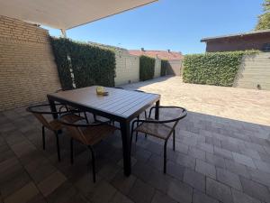 a wooden table and chairs on a patio at LUXURY Home Axel in Axel