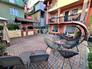 a patio with a table and chairs and a building at Cabana Mea STRAJA in Lupeni
