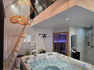 a bathroom with a large bath tub with a ladder at Sweety Loft - Hébergement avec SPA privé in Friville-Escarbotin +72 photos