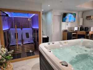 a large bathroom with a jacuzzi tub at Sweety Loft - Hébergement avec SPA privé in Friville-Escarbotin