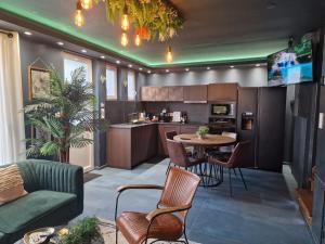 a kitchen and living room with a table and chairs at Sweety Loft - Hébergement avec SPA privé in Friville-Escarbotin