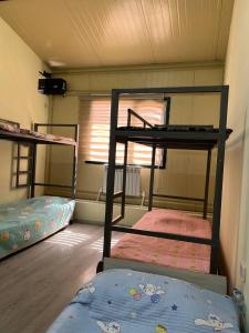 a room with three bunk beds and a window at Mezbon in Termiz +4 photos
