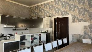 a kitchen with a table and chairs in a room at Mezbon in Termiz
