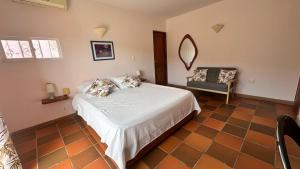 a bedroom with a bed with a mirror and a chair at Casa Bella Mya in Taganga