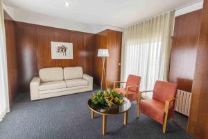 a living room with a couch and two chairs and a table at Hotel Eurosol Leiria & Jardim in Leiria