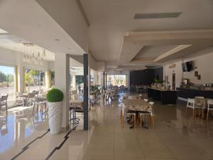 a dining room with tables and chairs and a kitchen at Hotel Cuesta de Miranda in Villa Unión