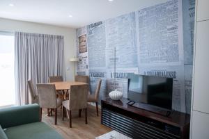 a living room with a television and a table with chairs at O Vilarealense Heritage Apartment in Vila Real