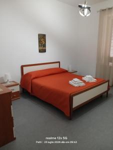 a bedroom with a bed with a red bedspread at Vico Girone in Patti
