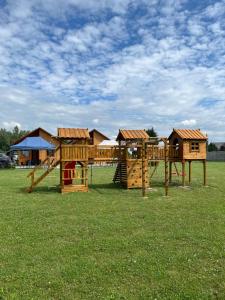 a playground with wooden play equipment in a field at Noclegi u Eli Zator Energylandia in Zator
