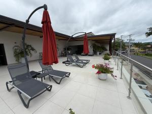 a group of chairs and umbrellas on a patio at livejaco405A in Jacó