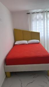 a bedroom with a bed with a red blanket at Carrasco D in Nagua