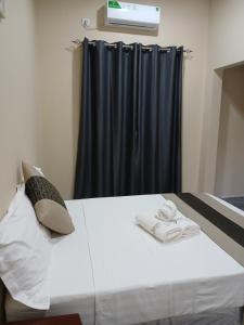 a bedroom with a bed with a black curtain at Casa T2 in Matola