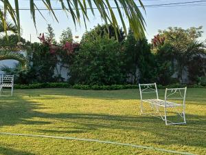 two chairs sitting on the grass in a yard at Casa T2 in Matola