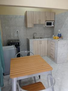 a kitchen with a wooden table and a table and chairs at Casa T2 in Matola