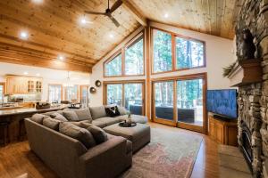 a living room with a couch and a fireplace at Luxury Cabin on Golf Course / Private Spa & Launch in Prattville +89 photos