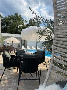 a patio with chairs and umbrellas and a pool at Villa Sveta Obitelj in Međugorje