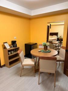 a room with a table and chairs and a mirror at Hospedaje Río Palomo in Orosí