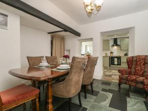 a kitchen and dining room with a wooden table and chairs at Fountain Cottage in Keswick +9 photos