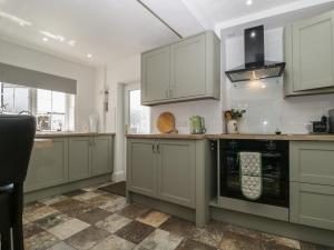 a kitchen with green cabinets and an oven at Fountain Cottage in Keswick