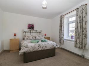 a bedroom with a bed and a window at Fountain Cottage in Keswick