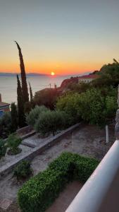 a view of the sunset from the balcony of a house at Myrto Signature Suite - Aegina in Aegenitissa