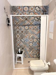 a bathroom with a toilet and a mosaic wall at Levante al porto in Bisceglie +17 photos