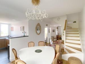 a dining room with a white table and a chandelier at Maison basque familiale Eguski Alde in Saint-Jean-de-Luz