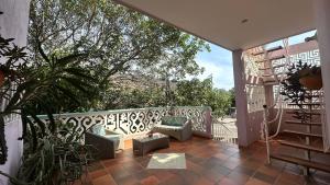 a balcony with chairs and plants on a balcony at Casa Bella Mya in Taganga