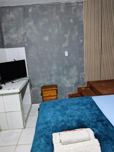 a room with a bed and a desk and a computer at suíte feliz in Belém