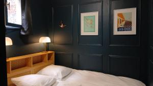 a bedroom with black walls and a bed with white sheets at Peaceful haven in Honfleur