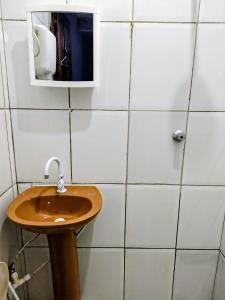 a bathroom with a sink and a mirror at suíte feliz in Belém