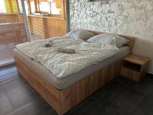 a large bed in a bedroom with a wooden frame at MAX Jazero in Trstice