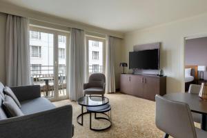 a living room with a couch and a television at Marriott Executive Apartments Brussels in Brussels