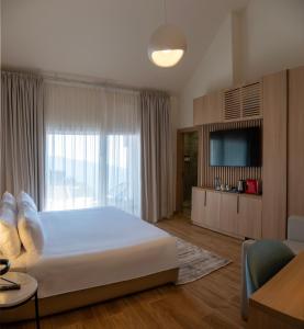 ein Schlafzimmer mit einem großen Bett und einem großen Fenster in der Unterkunft Ridge Hotel Ehden in Ehden