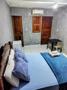 a bedroom with a bed with a blue blanket at suíte feliz in Belém +5 photos