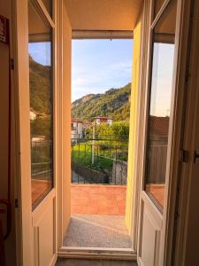a door leading to a balcony with a view at Olcium Holiday Rooms in Mandello del Lario