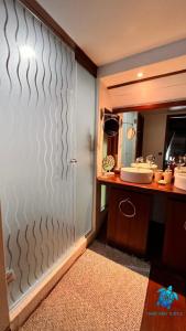 a bathroom with a shower with a sink and a mirror at Tiare and Turtle in Bora Bora