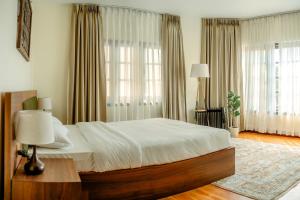 a bedroom with a large bed with white sheets at Gakyi Homes Boudha in Kathmandu