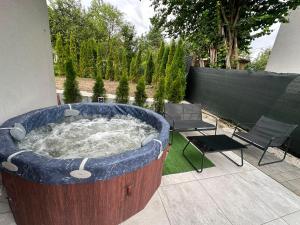 a hot tub in a yard with a table and chairs at Wisła Apartament Gór-SKI z jacuzzi in Wisła +53 photos