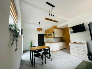 a kitchen with a table and chairs in a room at Wisła Apartament Gór-SKI z jacuzzi in Wisła